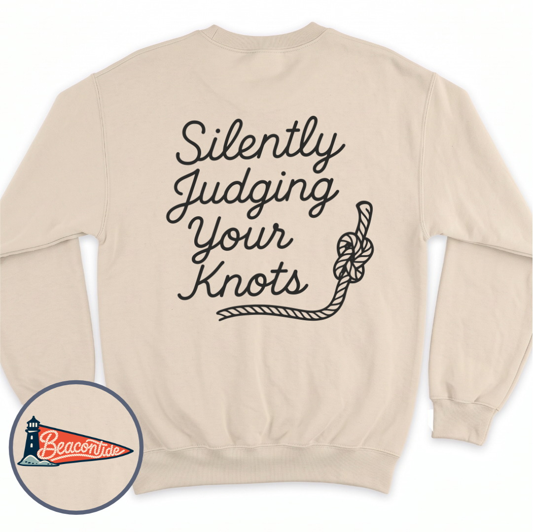 Silently Judging Knots crewneck sweatshirt in Sand, back view — script lettering Silently Judging Your Knots with a knotted rope, BeaconTide