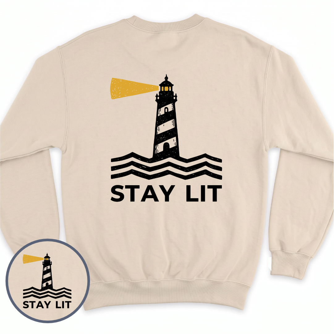 Stay Lit crewneck sweatshirt in Sand, back view — lighthouse graphic with the line Stay Lit, BeaconTide