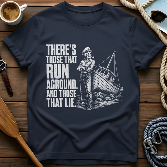 T-shirt with a skeleton captain smoking a pipe beside a sailboat run aground on rocks and text reading 'There's those that run aground. And those that lie.'